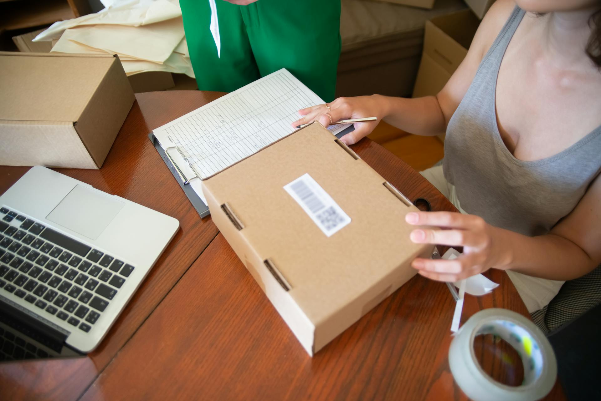 woman-sitting-at-the-table-and-packing-orders