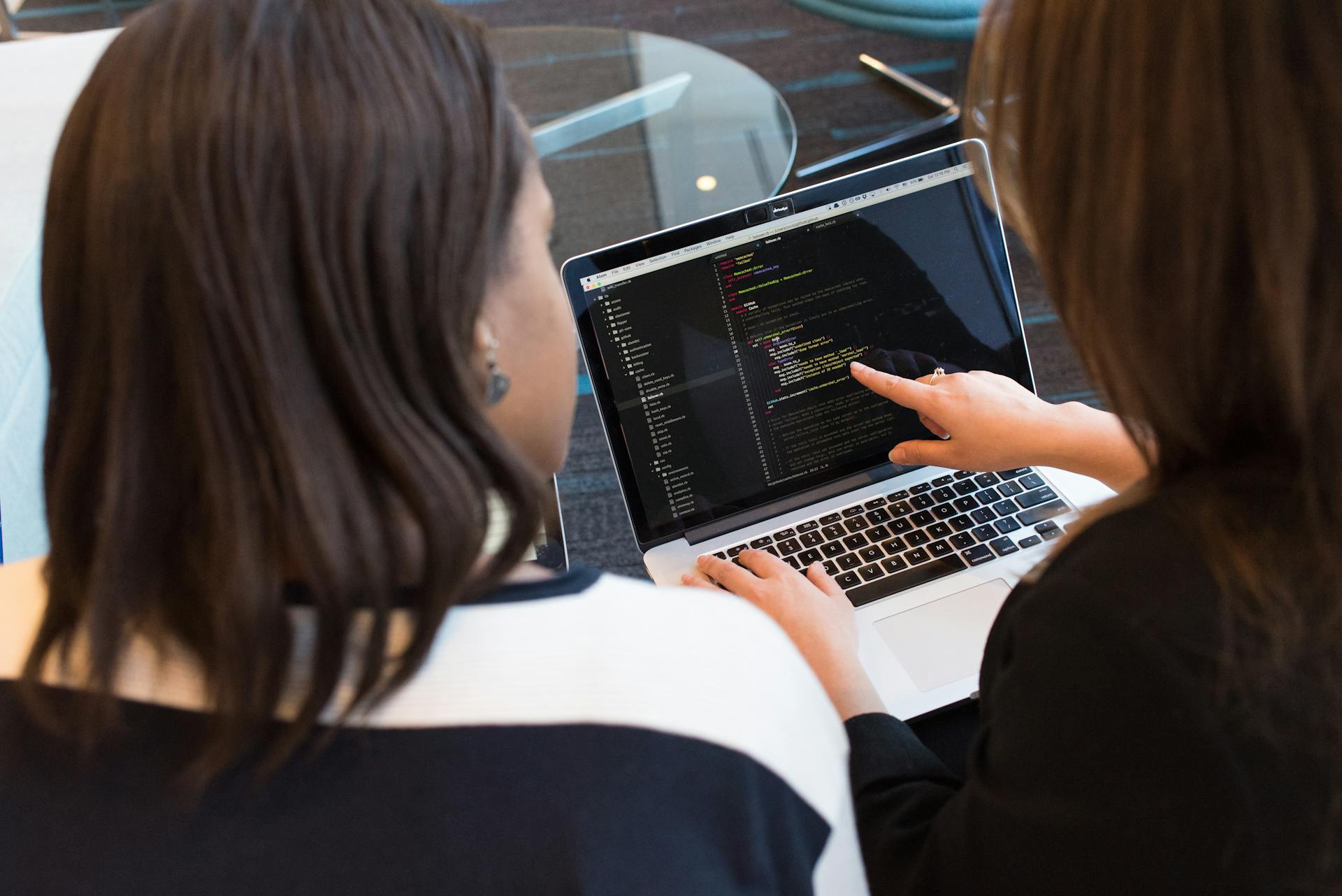 two-women-looking-at-the-code-at-laptop