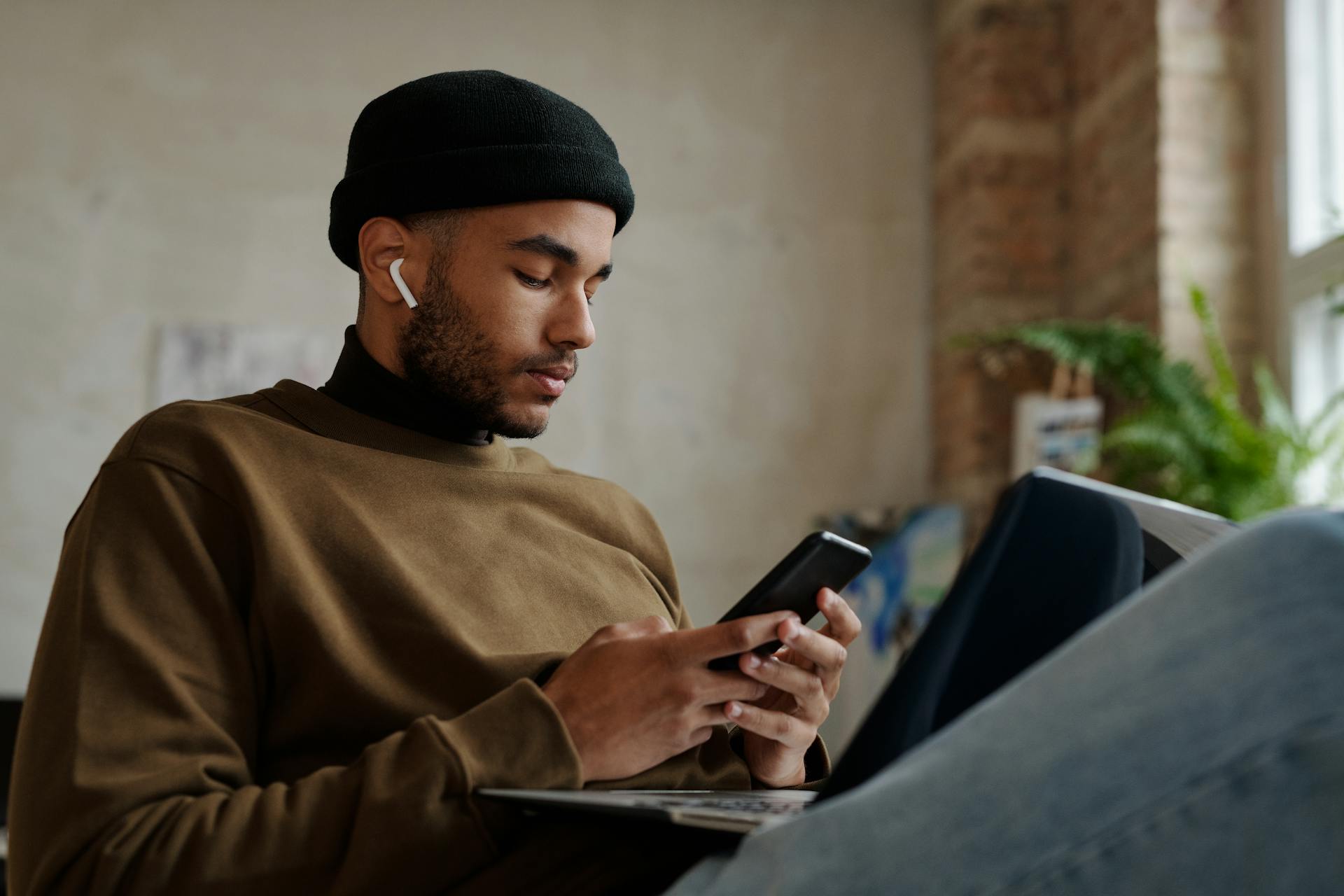 man-in-brown-sweater-using-phone