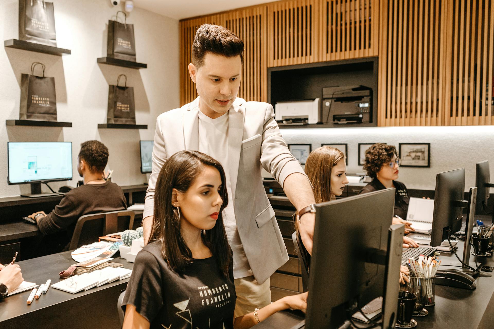 man-teaching-woman-in-front-of-monitor