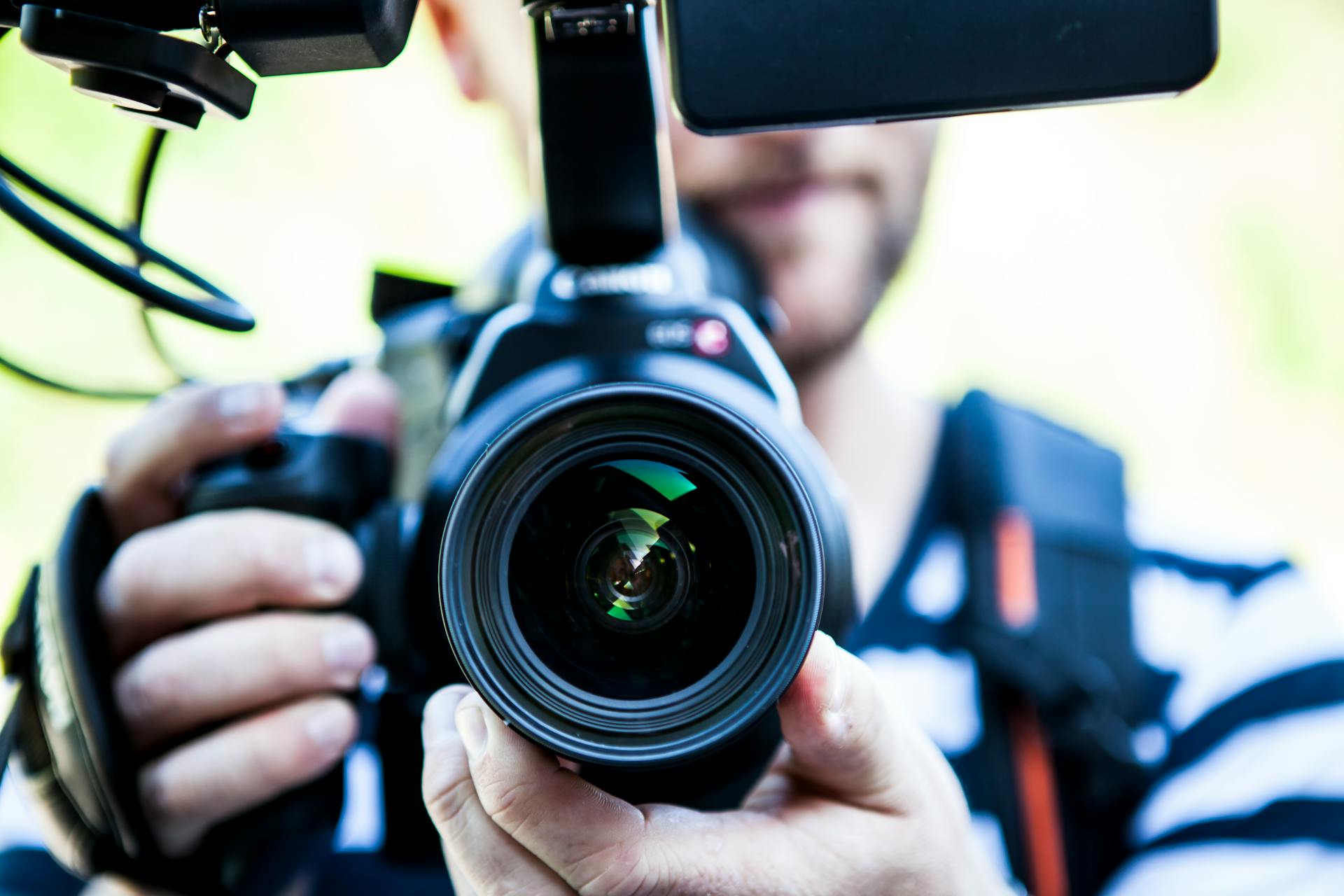 person-holding-canon-dslr-camera-close-up-photo