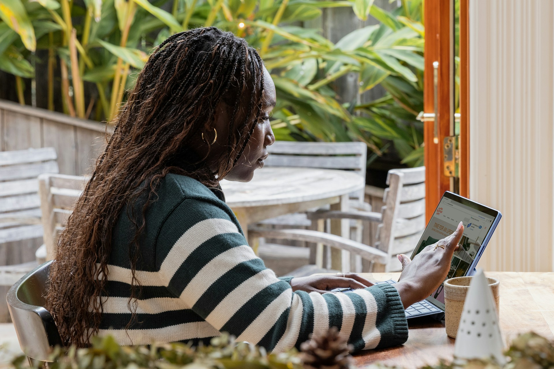 a-person-standing-in-front-of-a-laptop-computer-talking-on-a-cell-phone