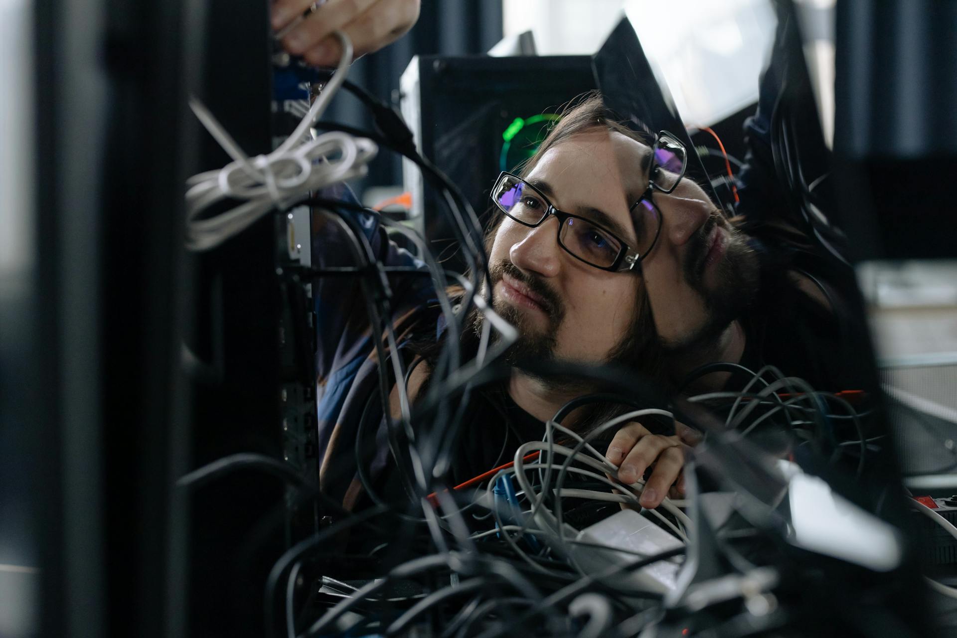 employee-working-through-the-tangle-of-cables-behind-the-computer