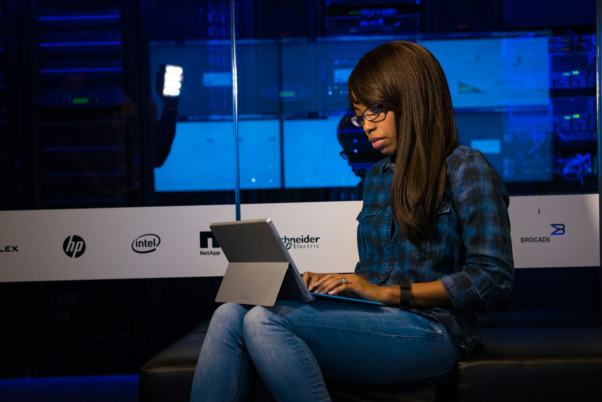 woman-in-blue-and-black-plaid-dress-shirt-using-laptop-computer