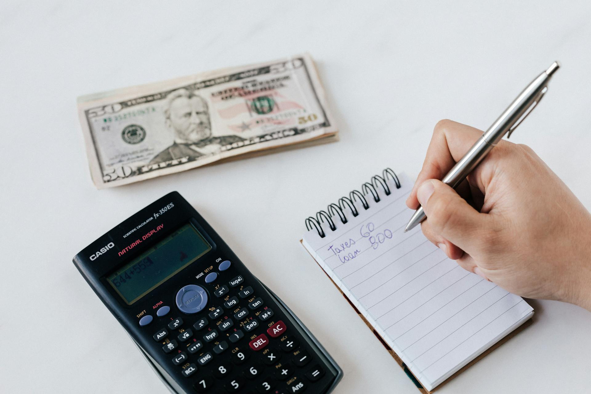 crop-anonymous-financier-planning-budget-writing-numbers-in-notebook