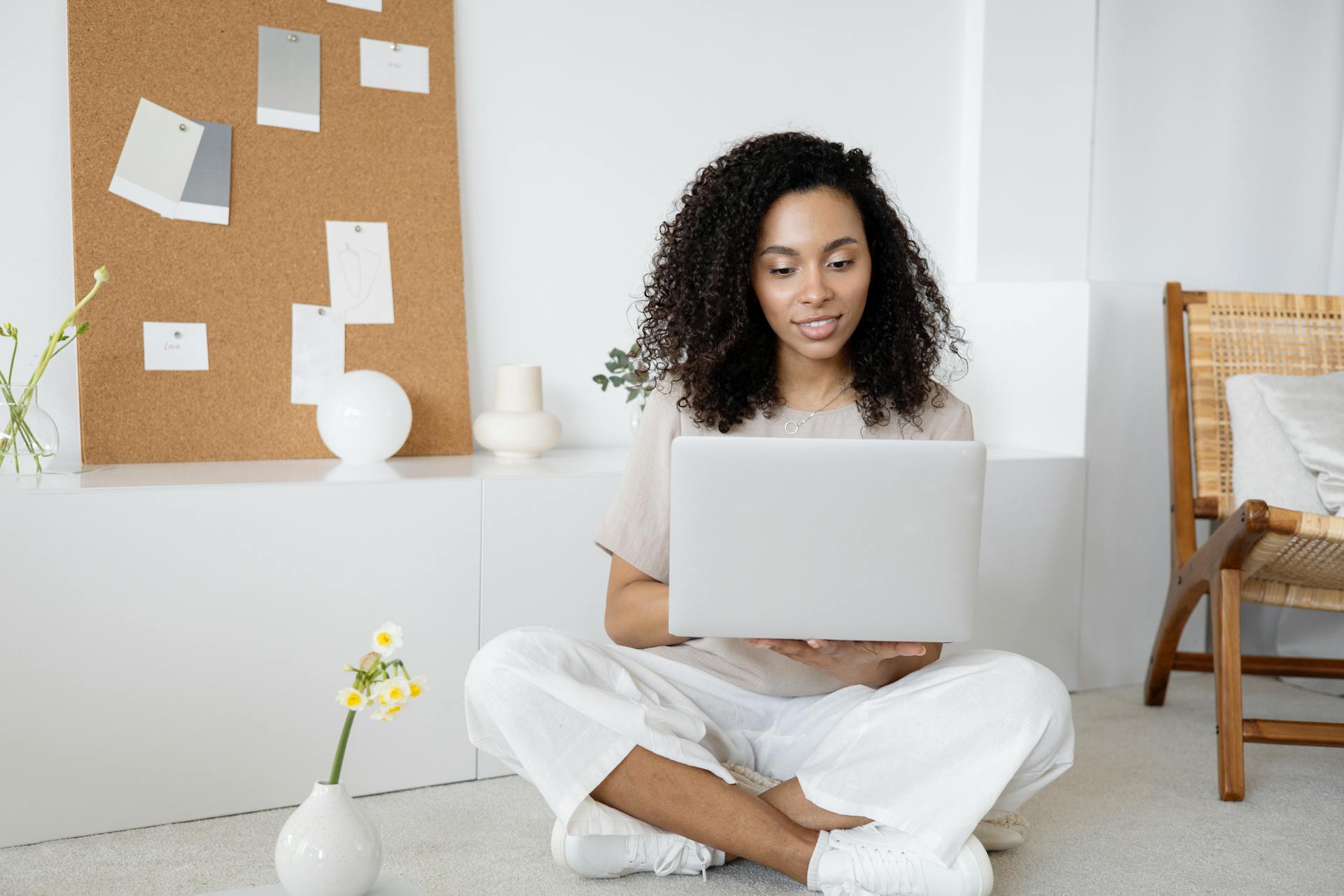 woman-in-white-dress-shirt-and-white-pants-sitting-on-floor-using-macbook