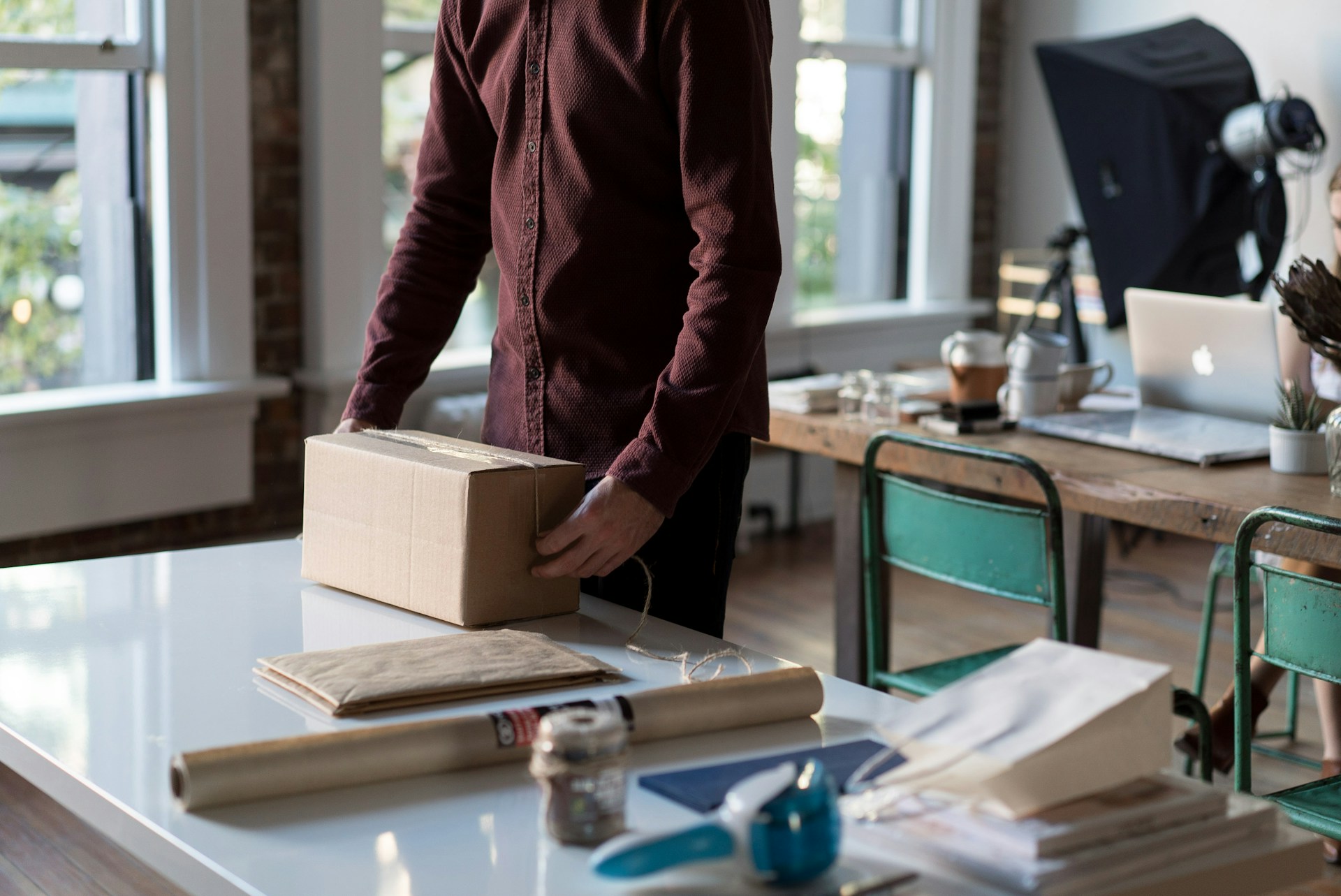 person-holding-cardboard-box-on-table