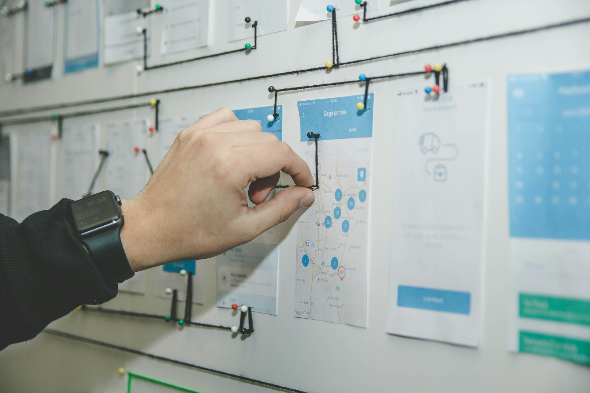 person-working-on-blue-and-white-paper-on-board