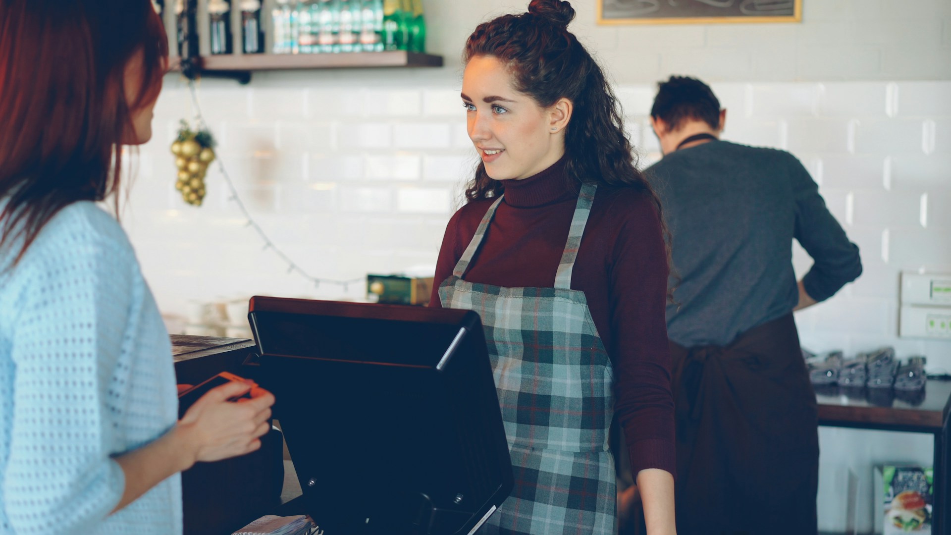 a-cafe-employee-serves-a-customer-at-the-register