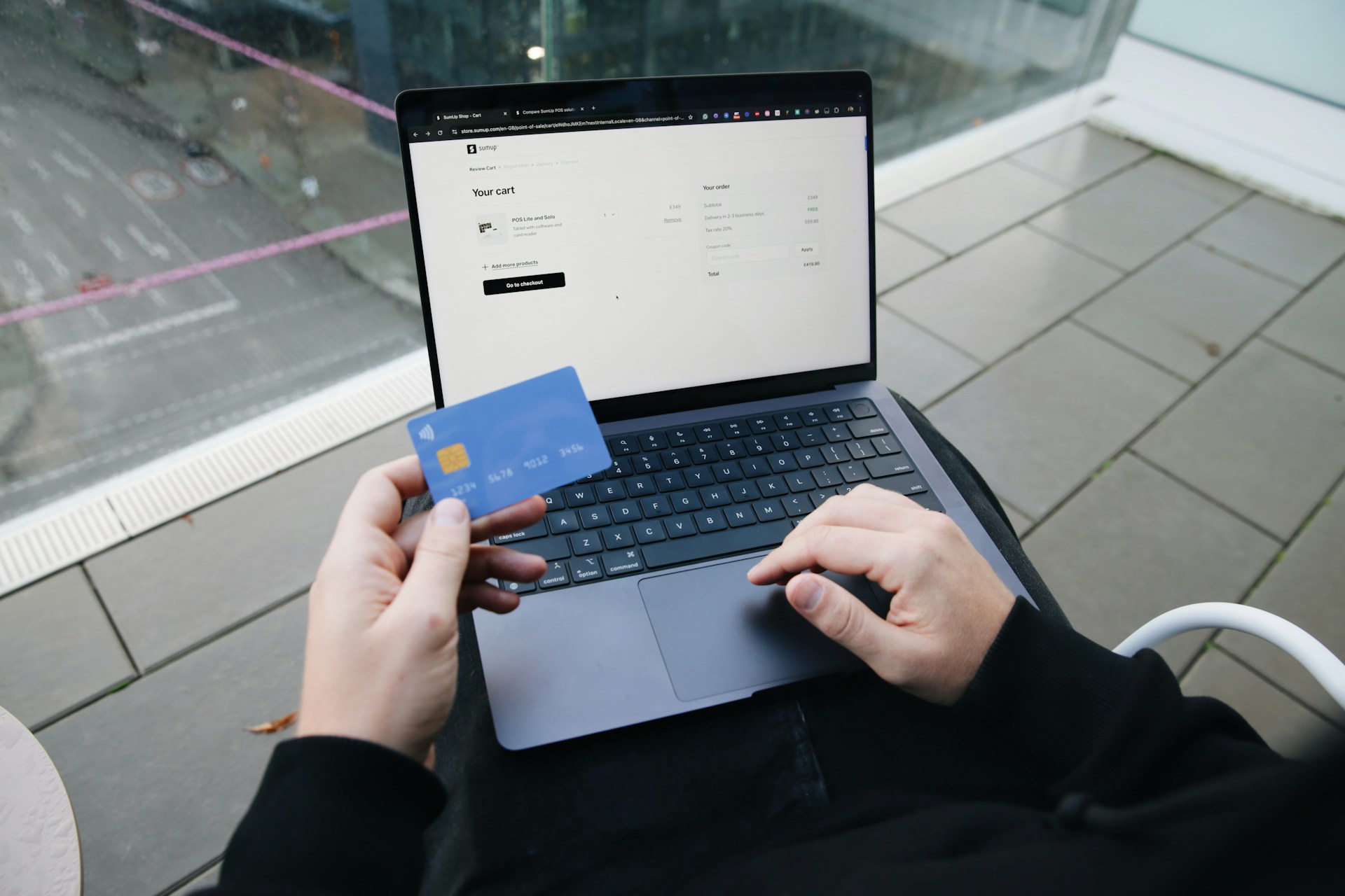 a-person-sitting-in-a-chair-with-a-laptop-and-a-credit-card