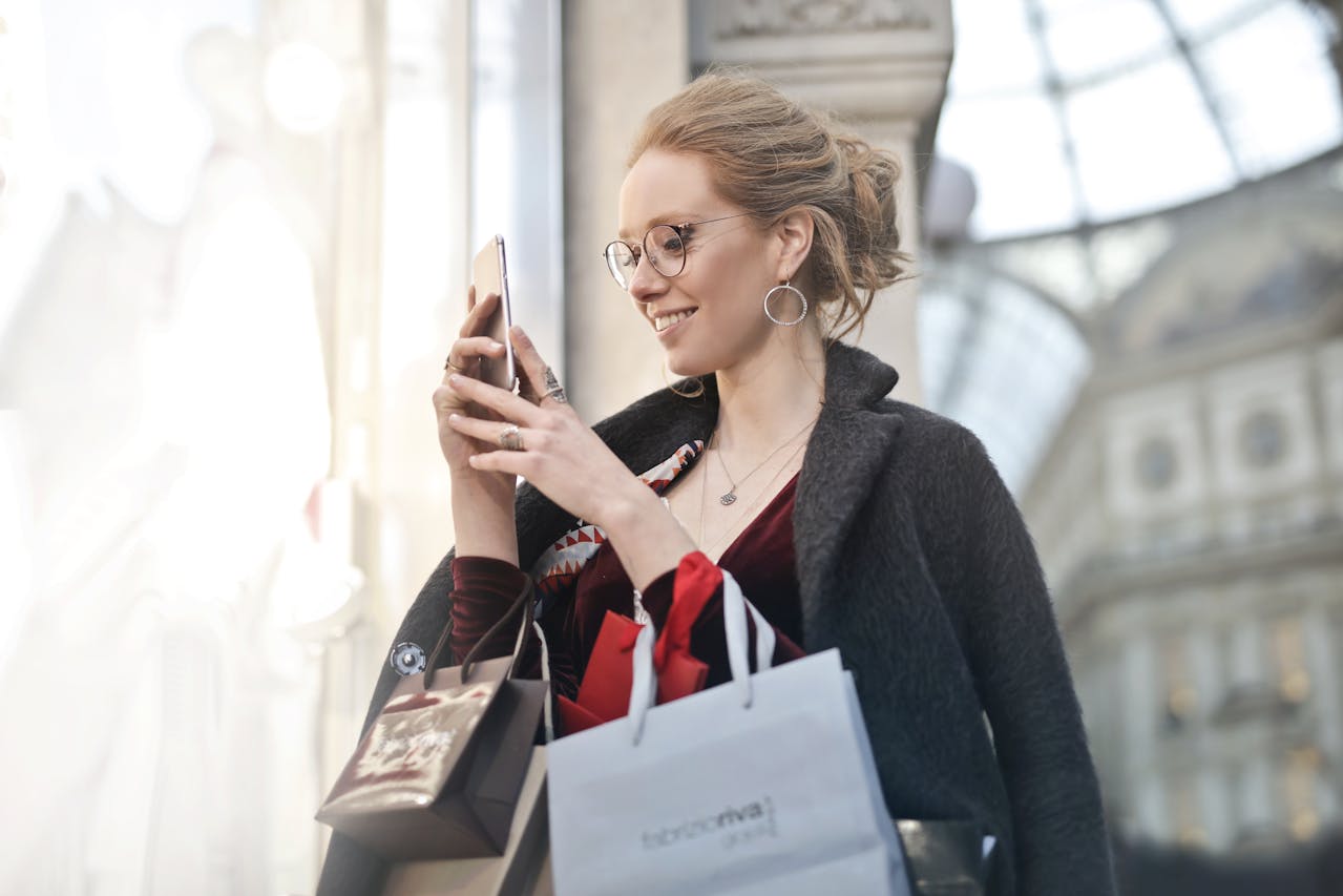 woman-standing-near-wall-holding-phone