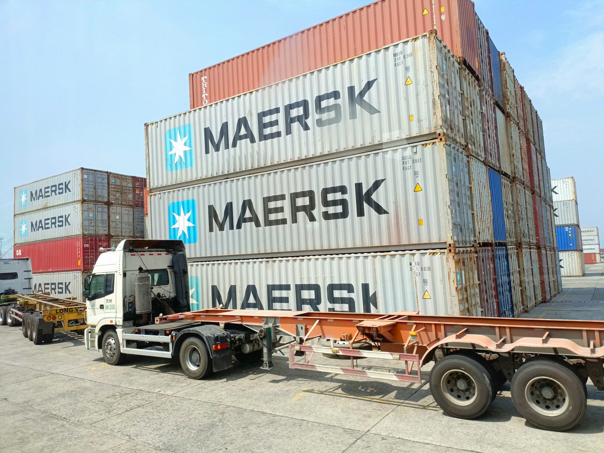 a-semi-truck-is-parked-next-to-a-large-container