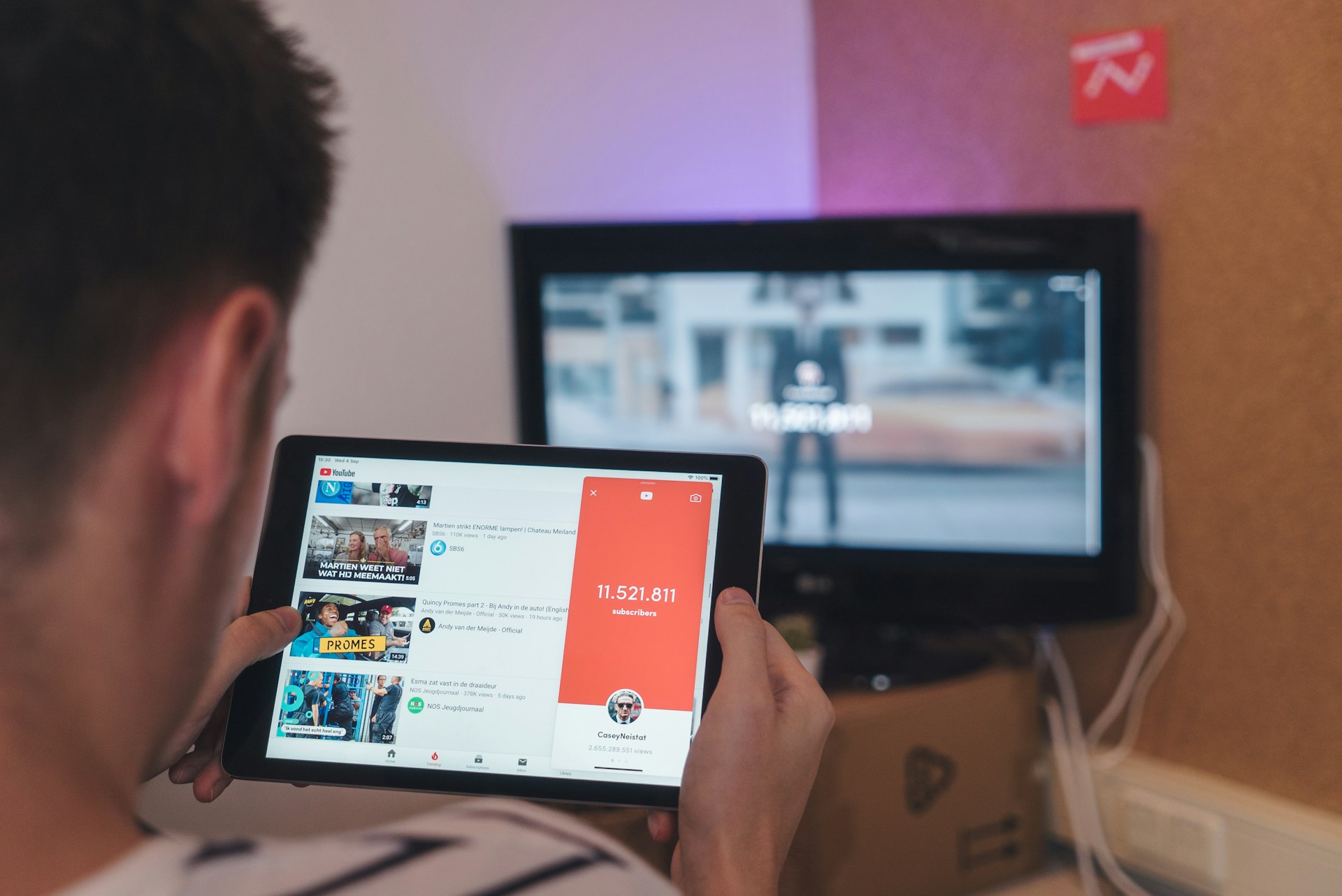 man-browsing-tablet-sitting-in-front-of-tv