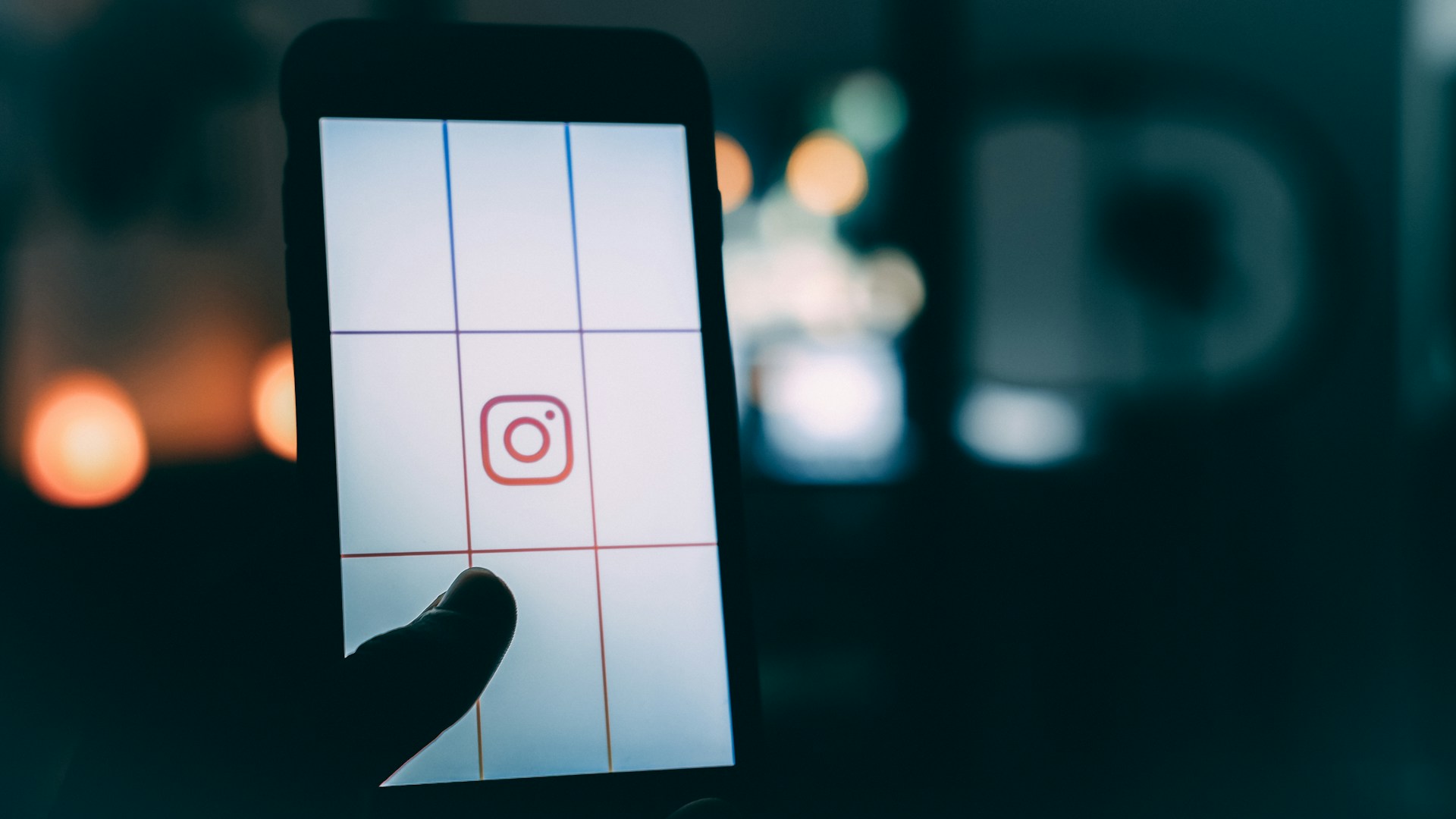 person-using-smartphone-with-instagram-logo-screengrab-bokeh-photography
